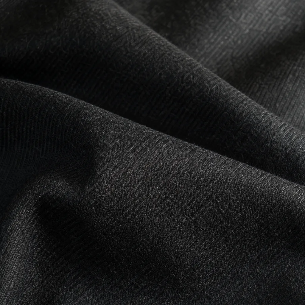 Detail of a fine merino suiting twill with a subtle diagonal rib in charcoal, soft directional sheen